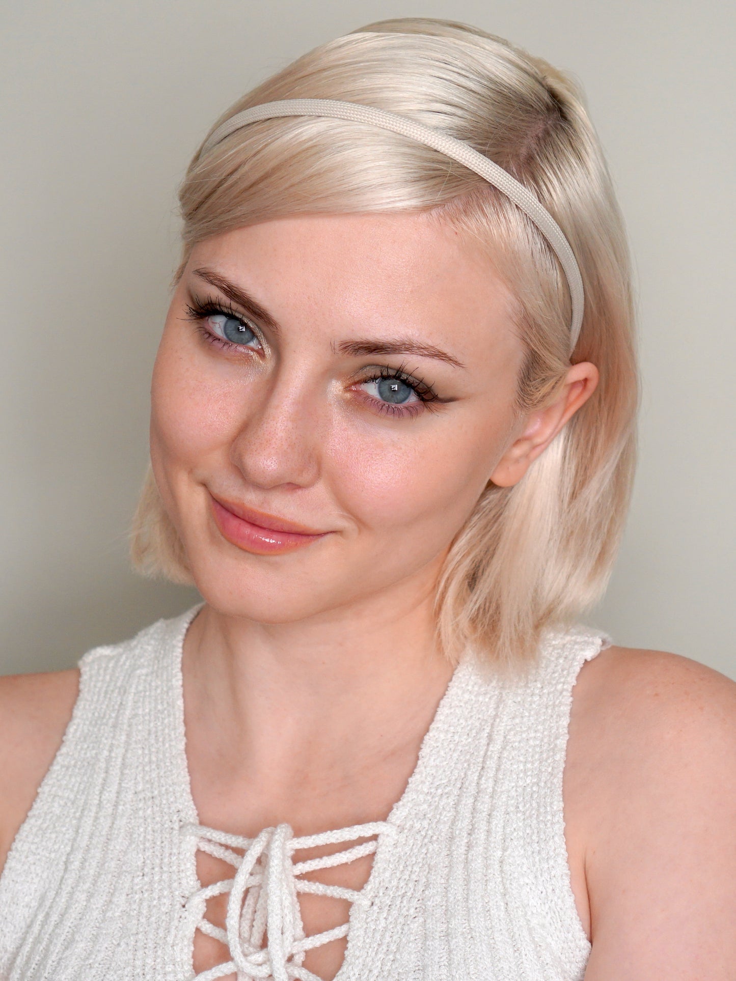 Blonde woman wearing light cream colored Heliums brand headband